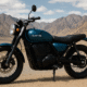Electric scrambler motorcycle parked in the Ladakh mountains under a clear sky.